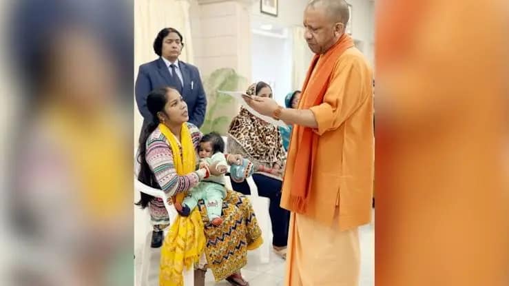 मुख्यमंत्री योगी आदित्यनाथ जनता दर्शन में बीमार बच्चे के सिर पर हाथ फेरते हुए